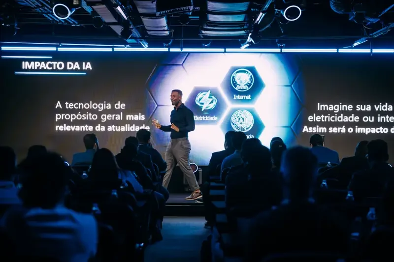 Tiago Rocha palestrando no palco para plateia corporativa